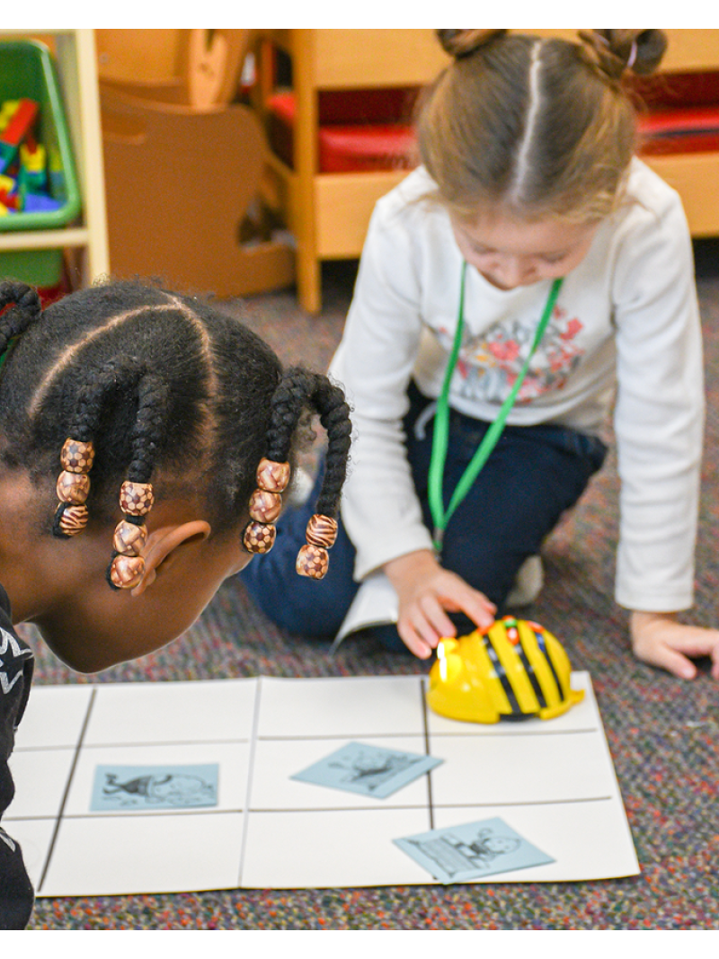 two girls using beebot